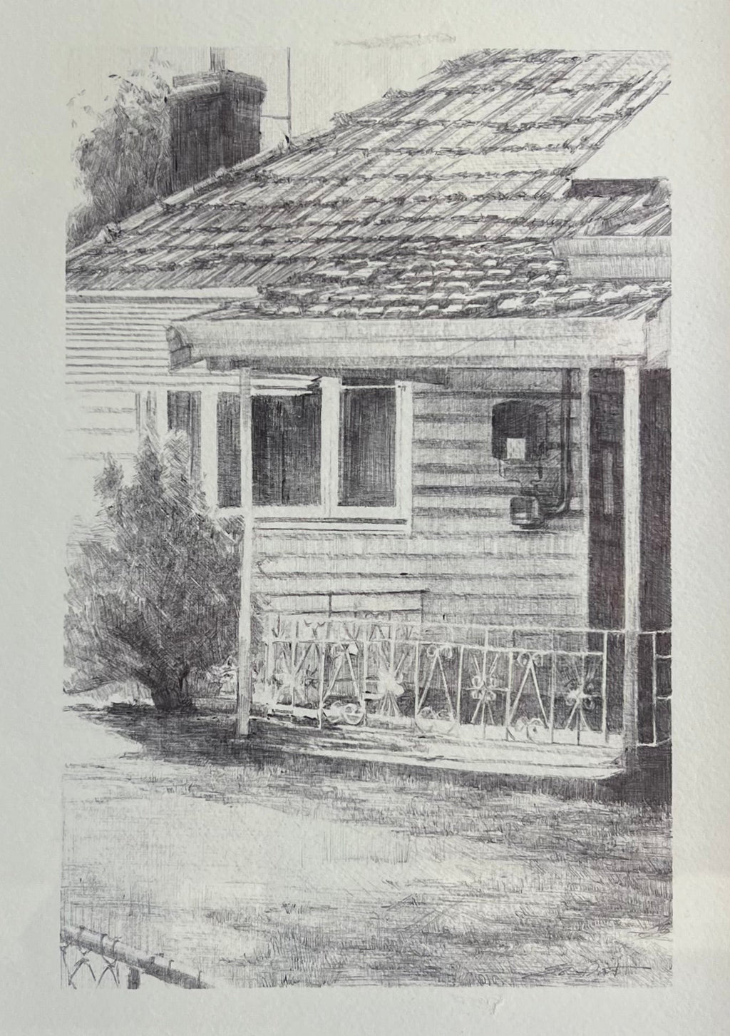 A framed black and white sketch print of a house with a porch, shown in a white mat and a dark frame.